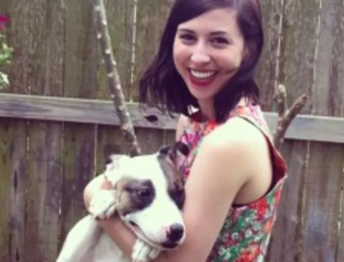 A woman holds a dog